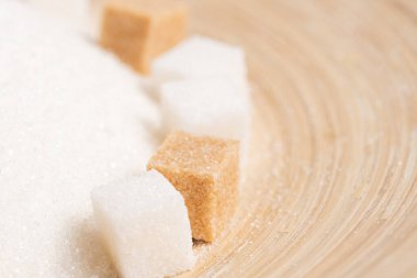 Tahta bir arka planda granüle şeker ve rafine kamış