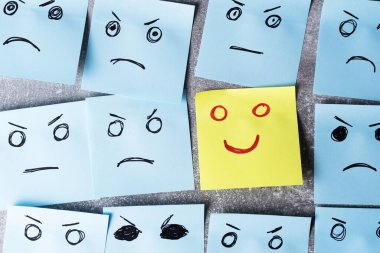 Concept positive attitude. Pieces of paper for notes with sad and angry emotions and one of them is funny