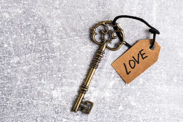 Stock image Old key with a tag with the word love