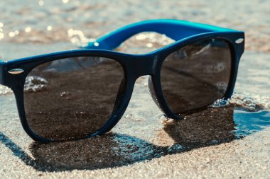 Kumsalda güneş gözlüğü. Yaz plaj tatili kavramı