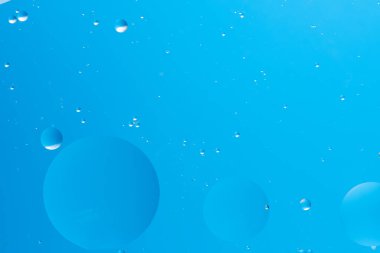 Yüzen çeşitli mavi baloncuklu açık mavi arkaplan