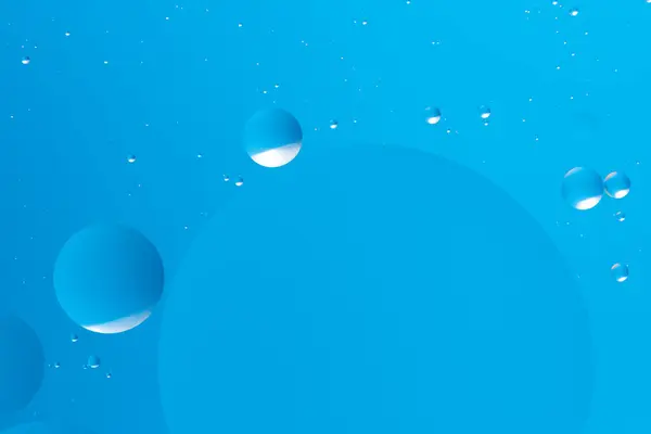 stock image Floating blue bubbles on a light blue background create a peaceful and minimalistic abstract design