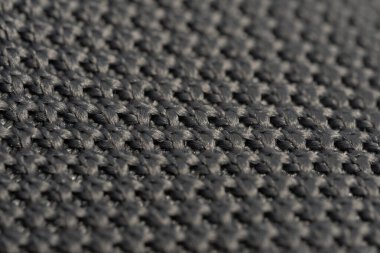 Gri örülmüş kumaştan yapılmış, dokulu bir makro detay. Soyut arkaplan