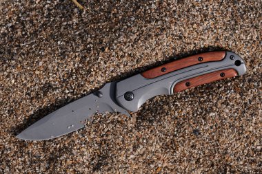 Kumsalda kumdaki av bıçağı, yakın plan.