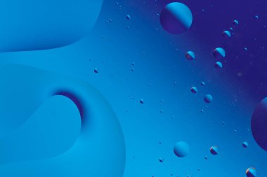 Mavi tonlu soyut görüntü, baloncuklar ve sakin ve rahatlatıcı görsel efektler yaratan sıvı şekiller.