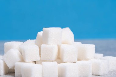 Mavi arka planda küp şekerler. Diyet ve sağlıklı gıda konsepti