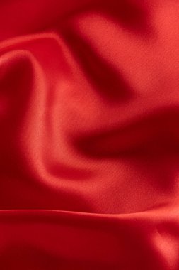 Dalgalanan kırmızı saten kumaş dokusu arkaplanının yakınlaştırılması