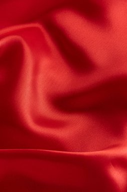Dalgalanan kırmızı saten kumaş dokusu arkaplanının yakınlaştırılması