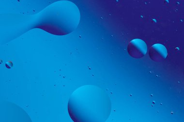 Mavi şekillerin ve baloncukların soyut bileşimi, sakin bir sıvı sahneyi andıran pürüzsüz, akışkan bir desen oluşturur..