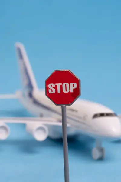 stock image Stop sign and airplane model on blue background. Travel concept