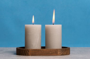 Mumları ahşap tutacakta yakmak mavi arkaplanda kopyalama alanı ile