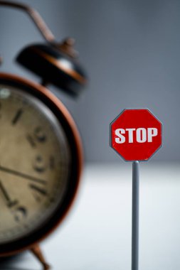 Stop sign with alarm clock on the background. Stop time concept clipart