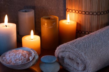 Mumlar, havlular ve ahşap masada deniz tuzu ile kaplıca hayatı