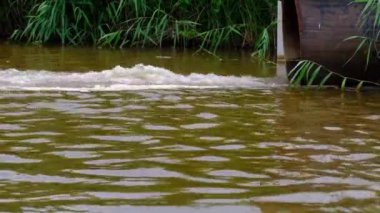 Fabrika sıvısı atıkları borudan nehre çekilerek kirli köpük oluşturur. Çevre kirliliği ve ekoloji.