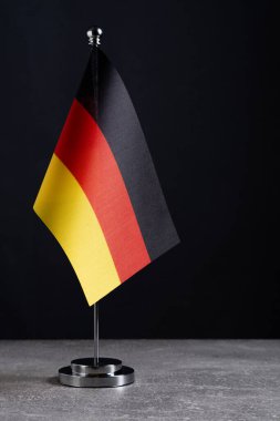Alman Bayrağı siyah arka planda duruyor. Metin için yer