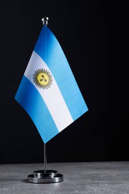 Gri beton masada metal bayrak direğinde Arjantin bayrağı