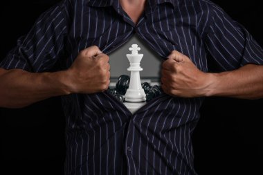 Man tears open his shirt, revealing white chess piece king inside, symbolizing strategy and inner strength clipart