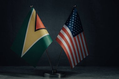 Masa bayrakları Amerika Birleşik Devletleri ve Guyana bayrağını koyu arka planda