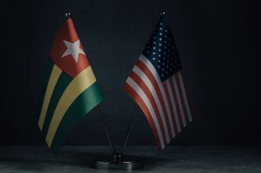 Masa bayrakları Amerika Birleşik Devletleri ve Ulusal Bayrak Togo 'nun koyu arkaplanda