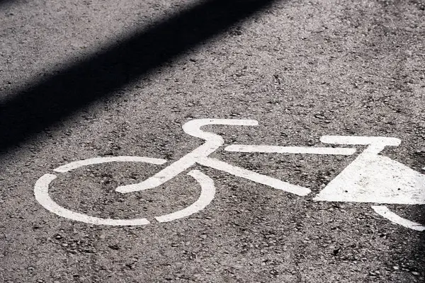 Bisiklet yolu tabelası asfalt yolda. Gölgesi güneşten.