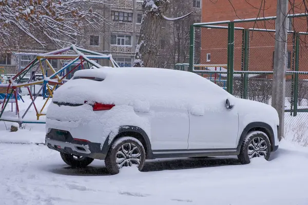 Araba kışın şehrin oyun parkında karla kaplıydı.