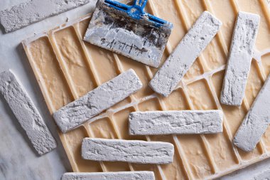 İnşaat alçıtaşı dökmek için dekoratif tuğlalar, spatula ve silikon küf hazır.