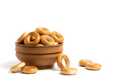 Beyaz arka planda içi simit dolu ahşap bardak.