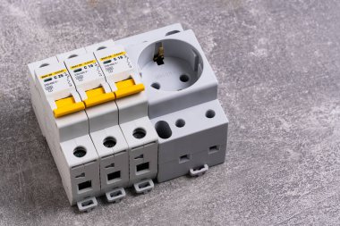 Gri arka planda prizi olan elektrik sigorta kutusu, yakın plan.