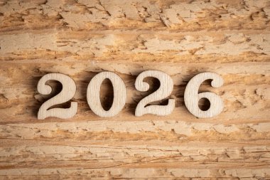 Eski ahşap arka planda 2026 numaralı tahta. Mutlu yıllar 2026.