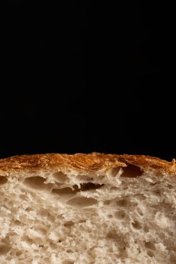 Siyah arkaplanda bir dilim ciabatta ekmeği.