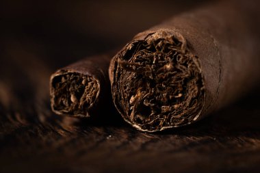 Cigar on wooden background. Selective focus clipart