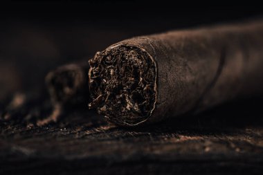 Siyah ahşap arka planda bir puro. Seçici odaklanma. Ayarlanmış