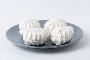 Beyaz arka planda gri tabakta beyaz şekerlemeler