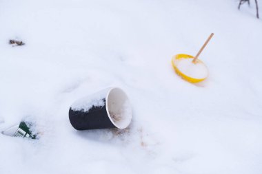 Kar üzerinde saman bulunan tek kullanımlık plastik bardak.