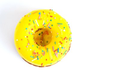 Üzerinde serpinti olan sarı çörek beyaz arkaplanda izole edilmiş.