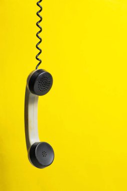 Sarı arkaplanda metin için kopyalama alanı olan telefon ahizesi