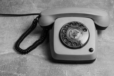 Gri arka planda klasik telefon. Siyah beyaz görüntü. Boşluğu kopyala