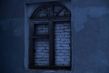 Ahşap çerçeveli eski pencere, tuğlayla örülmüş.