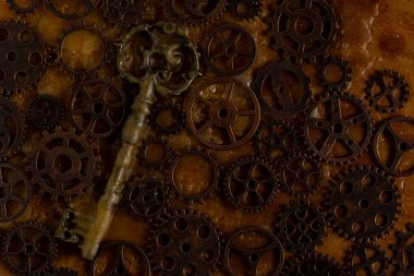 Eski bir arkaplanda eski anahtar ve metal dişliler