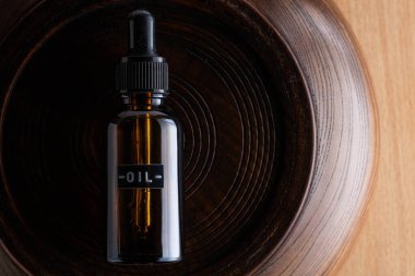 Ahşap arka planda bir şişe gerekli yağ. Üst görünüm