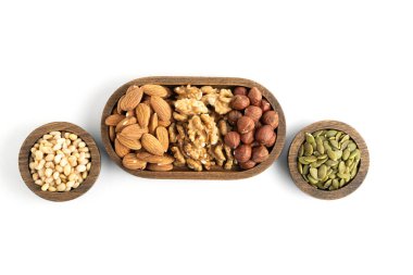 Beyaz arka planda izole edilmiş ahşap kaselerde karışık fındıklar. Üst görünüm