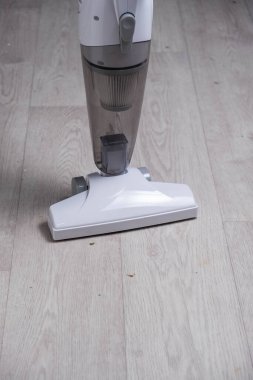 Tahta zeminde elektrikli süpürge var. Temizlik hizmeti kavramı