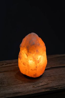 Ahşap arka planda parlayan tuz lambası. Klasik stil