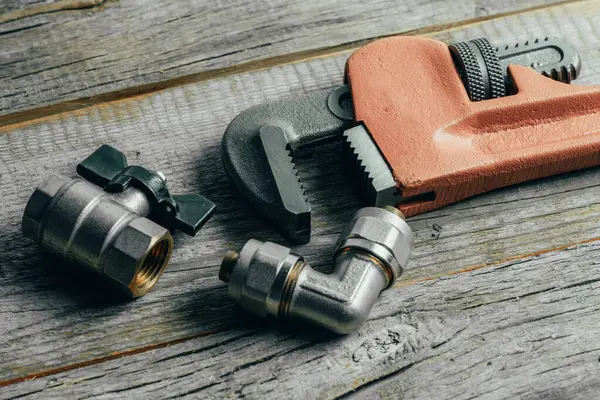 Ahşap arka planda tesisat araçları. Tesisat işi kavramı