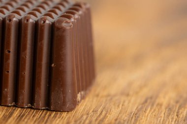 Çikolatanın bir kısmı ahşap arka planda.