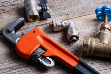 Ahşap arka planda tesisat aletleri ve ekipmanlar. Tesisat konsepti