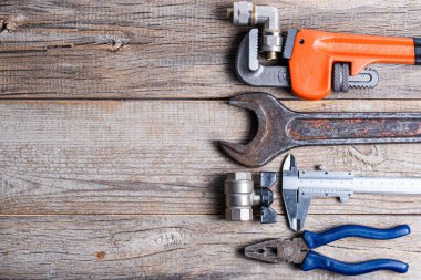 Ahşap arka planda çeşitli tesisat aletleri var. Kopyalama alanı olan üst görünüm