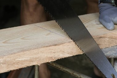 Testereyle odun kesen adam, yakın plan.