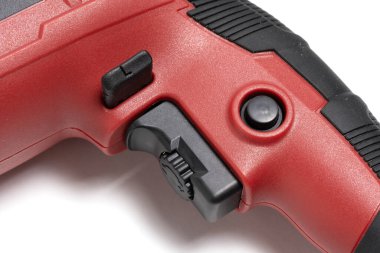 Beyaz arkaplanda kontrol düğmeleri olan kırmızı elektrikli matkap.