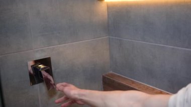 Banyodaki duşu tavan arası tasarımı ile açan kişi, kahverengi ahşap, duvarlarda gri beton döşemeler, düşen damlalarla akan su. Yüksek kalite 4k görüntü